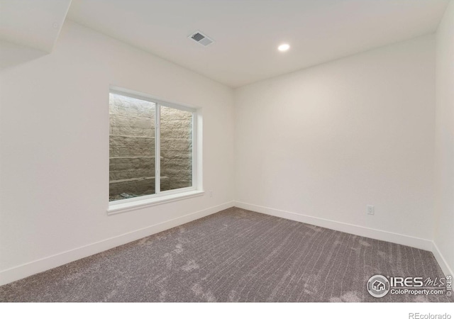 unfurnished room with recessed lighting, baseboards, visible vents, and dark carpet