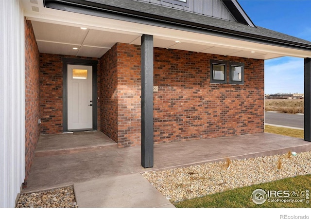 entrance to property with brick siding and board and batten siding