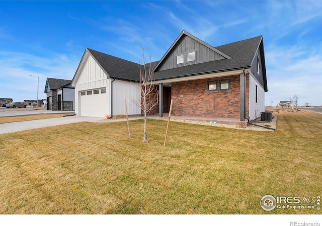 view of front of property with board and batten siding, a front lawn, central AC, a garage, and driveway