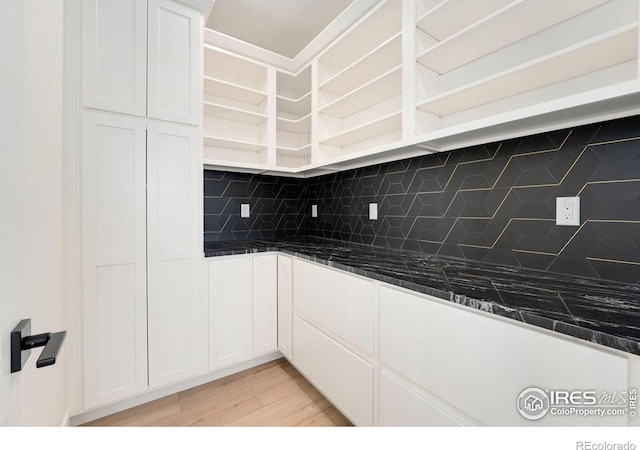 kitchen with dark countertops, decorative backsplash, white cabinetry, and open shelves