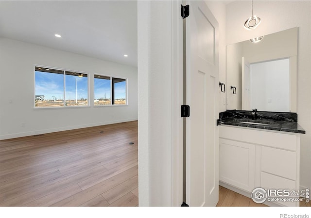 bathroom with visible vents, baseboards, recessed lighting, wood finished floors, and vanity