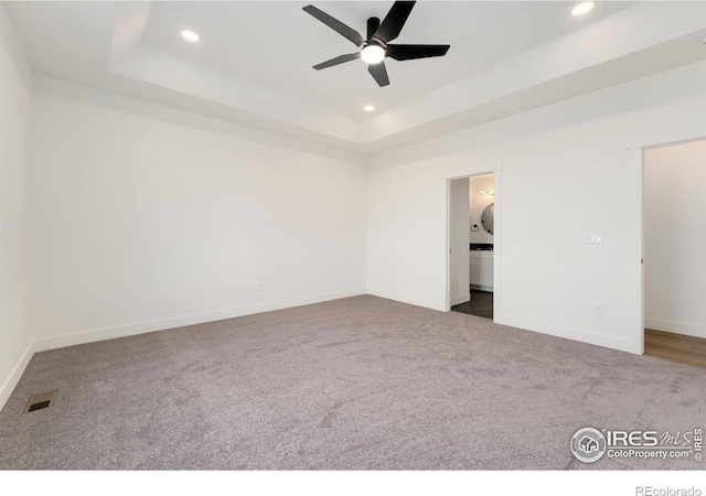 unfurnished bedroom with visible vents, recessed lighting, and a tray ceiling