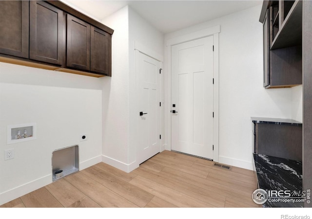 washroom featuring electric dryer hookup, light wood-style flooring, cabinet space, baseboards, and hookup for a washing machine