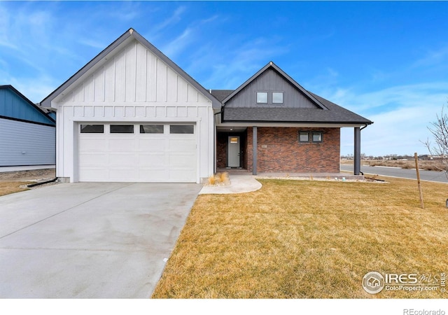 view of front facade featuring driveway, a front lawn, board and batten siding, an attached garage, and brick siding