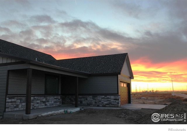 property exterior at dusk featuring a garage