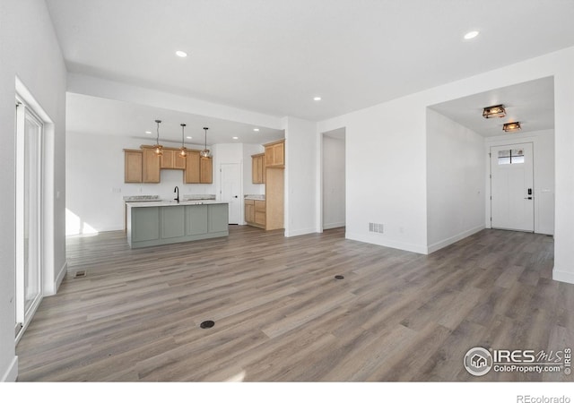 448 Cache Ave, Fort Morgan, CO 80701 - unfurnished living room with a sink, visible vents, light wood-style flooring, and recessed lighting