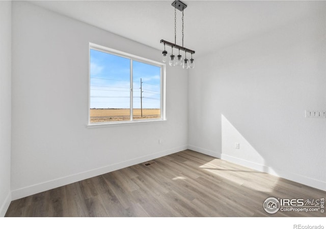 448 Cache Ave, Fort Morgan, CO 80701 - unfurnished dining area with baseboards, visible vents, and wood finished floors