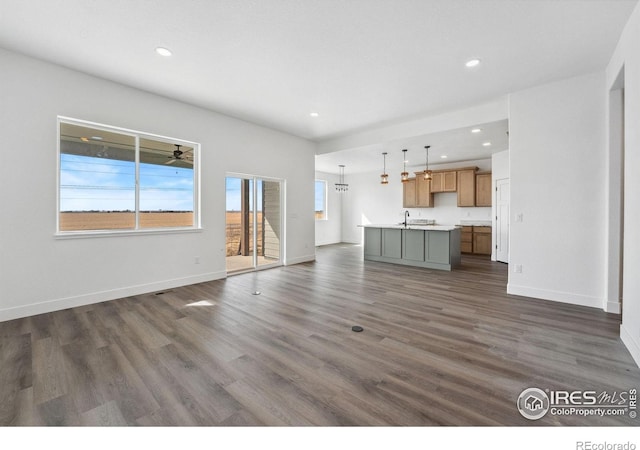 448 Cache Ave, Fort Morgan, CO 80701 - unfurnished living room with recessed lighting, a sink, baseboards, and dark wood finished floors