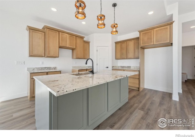 448 Cache Ave, Fort Morgan, CO 80701 - kitchen with light wood finished floors, baseboards, a kitchen island with sink, recessed lighting, and a sink