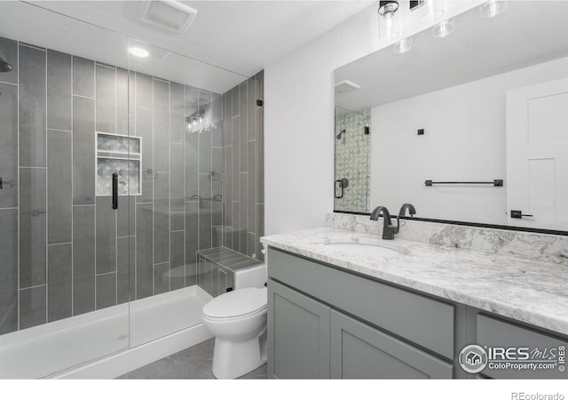 448 Cache Ave, Fort Morgan, CO 80701 - full bathroom featuring vanity, visible vents, toilet, and a shower stall