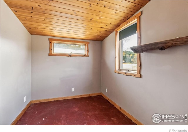 spare room featuring dark carpet, vaulted ceiling, and wooden ceiling