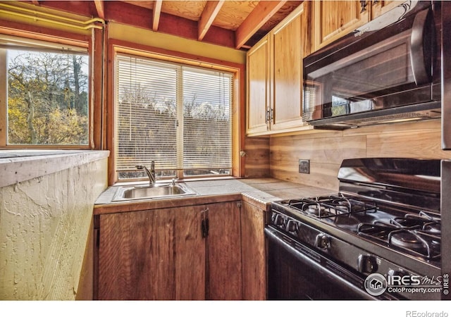 kitchen with tile countertops, sink, a healthy amount of sunlight, and black appliances