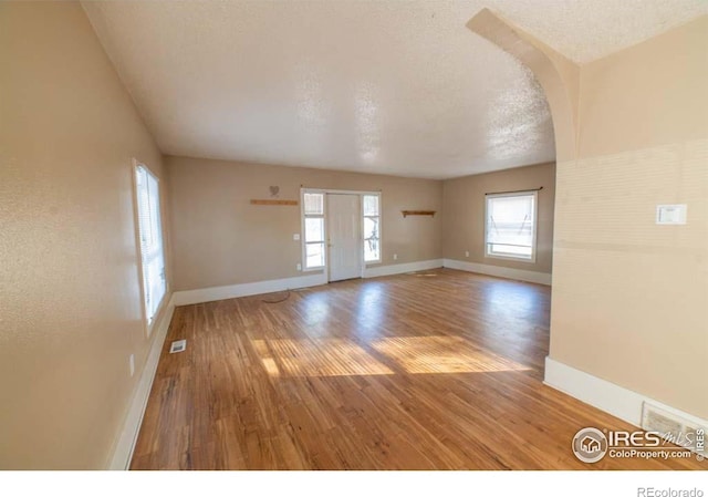 unfurnished room featuring hardwood / wood-style floors and a textured ceiling