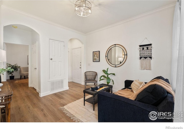 living room featuring light wood-type flooring and crown molding