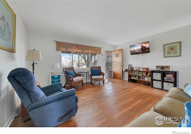 living room with hardwood / wood-style flooring and a textured ceiling