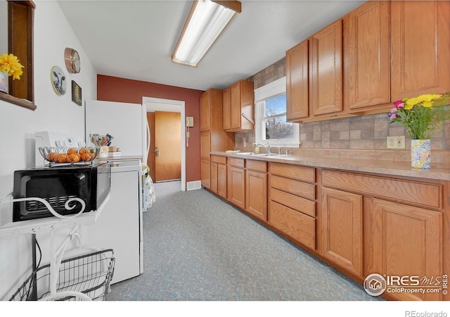 kitchen featuring tasteful backsplash, white fridge, and sink