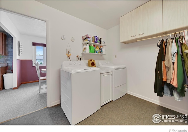 clothes washing area with washing machine and dryer, dark colored carpet, and cabinets