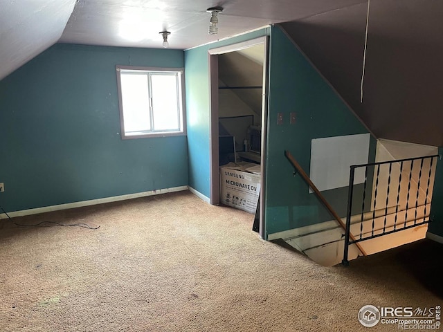 additional living space with vaulted ceiling and carpet