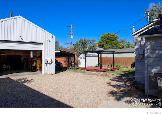 view of yard with a garage, a shed, and a carport