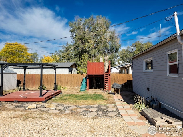 view of yard featuring a deck and a playground