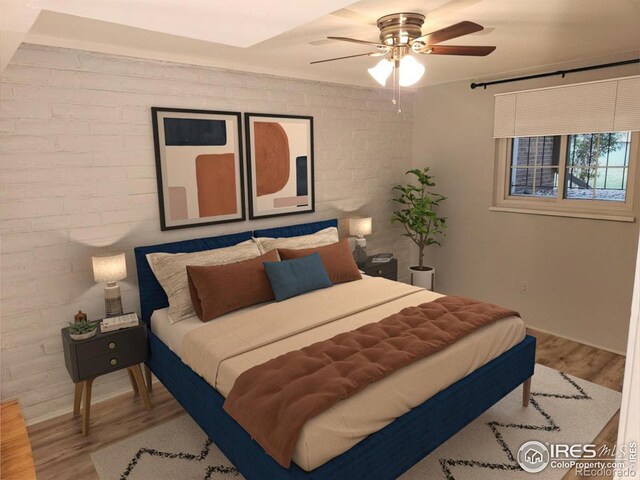 bedroom with brick wall, hardwood / wood-style floors, and ceiling fan