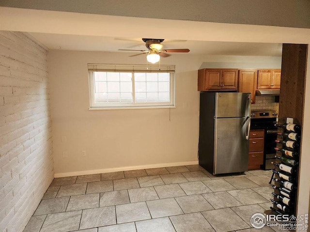 kitchen with ceiling fan, light tile patterned floors, brick wall, appliances with stainless steel finishes, and decorative backsplash