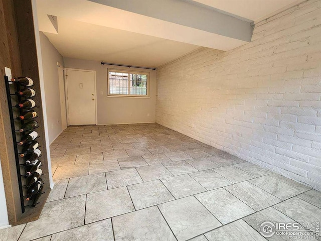 unfurnished room with brick wall