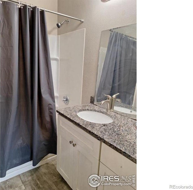 bathroom featuring hardwood / wood-style flooring, vanity, and a shower with curtain