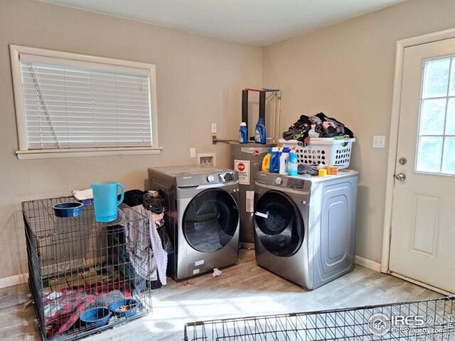 clothes washing area featuring washer and clothes dryer and hardwood / wood-style floors