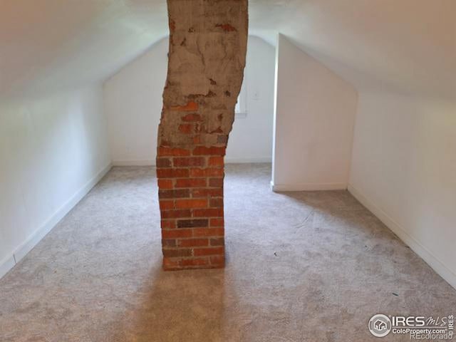 additional living space with vaulted ceiling and light colored carpet