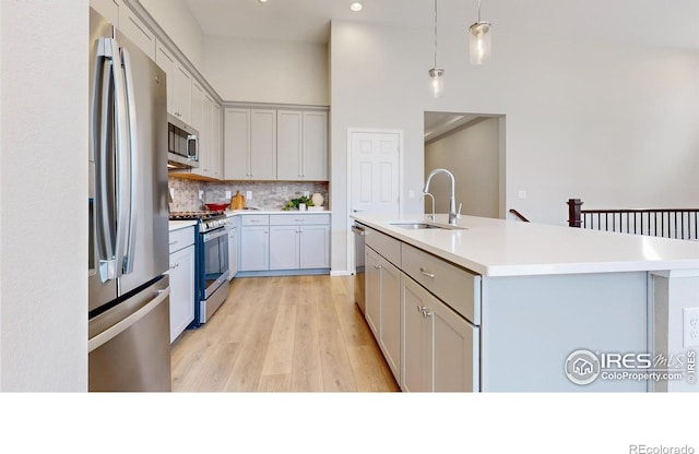3107 Deering Lake Dr, Loveland, CO 80538 - kitchen with a sink, an island with sink, light countertops, backsplash, and appliances with stainless steel finishes