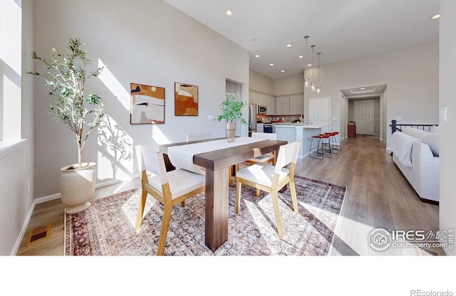 3107 Deering Lake Dr, Loveland, CO 80538 - dining space featuring recessed lighting, a high ceiling, visible vents, and light wood-style flooring