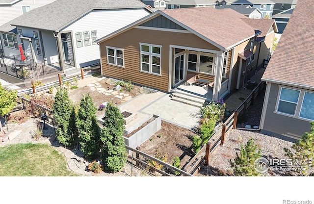 3107 Deering Lake Dr, Loveland, CO 80538 - rear view of house featuring fence, board and batten siding, a shingled roof, and a vegetable garden