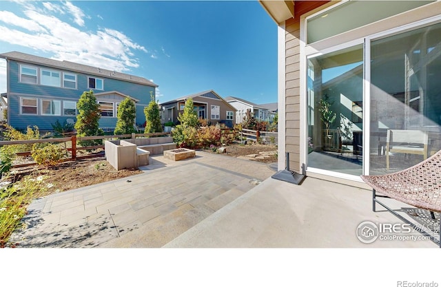 3107 Deering Lake Dr, Loveland, CO 80538 - view of patio with fence, an outdoor fire pit, and a residential view