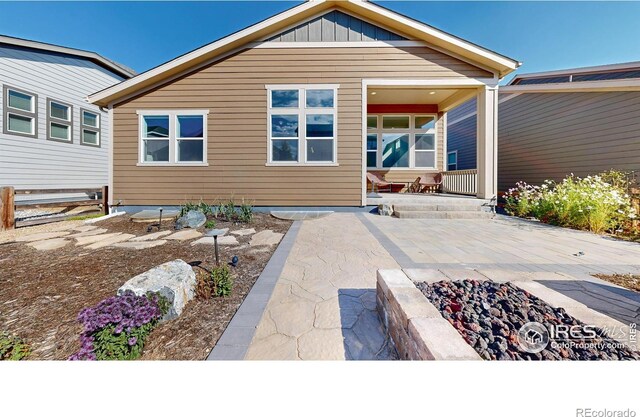 3107 Deering Lake Dr, Loveland, CO 80538 - rear view of house with board and batten siding, a patio, and an outdoor fire pit