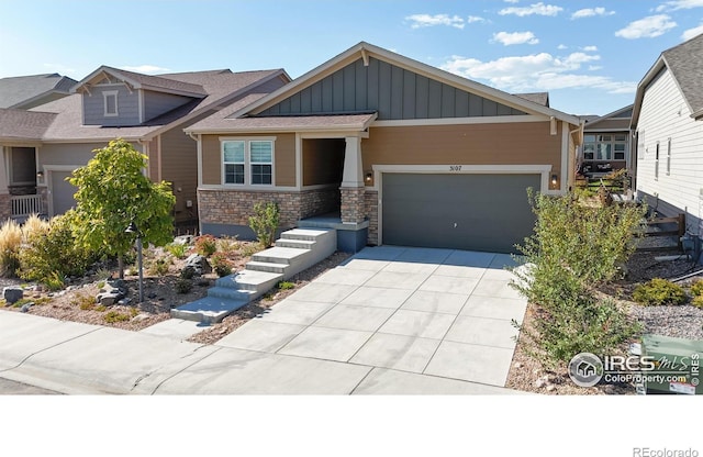 3107 Deering Lake Dr, Loveland, CO 80538 - view of front of home featuring board and batten siding, driveway, stone siding, and a garage