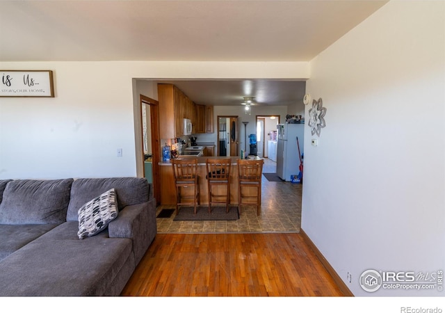 living room featuring dark hardwood / wood-style floors and ceiling fan