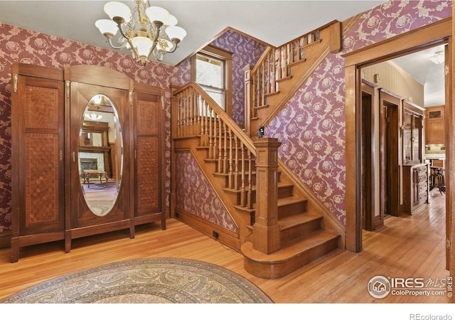 entrance foyer with hardwood / wood-style floors and an inviting chandelier