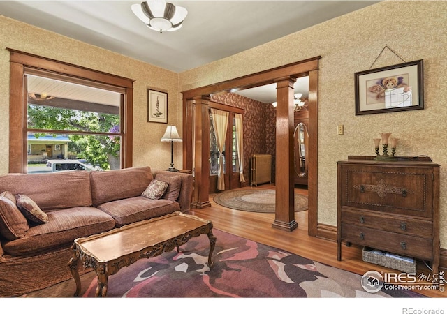 living room with wood-type flooring and decorative columns