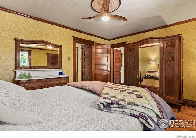 bedroom with crown molding, hardwood / wood-style flooring, and ceiling fan