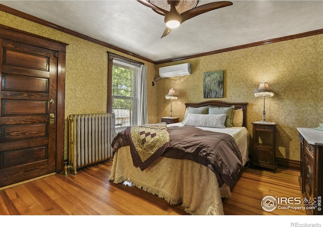 bedroom featuring a wall unit AC, ceiling fan, wood-type flooring, crown molding, and radiator