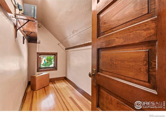 interior space with lofted ceiling and light hardwood / wood-style flooring