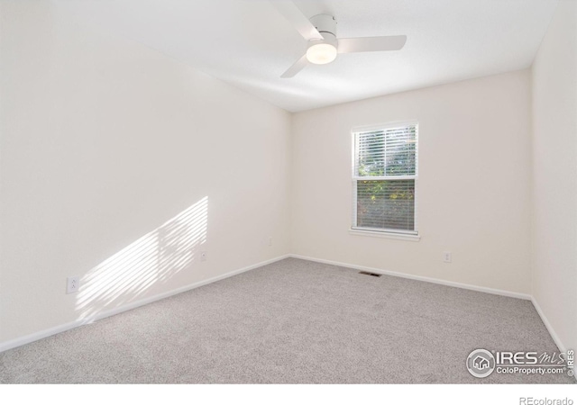 carpeted spare room with ceiling fan