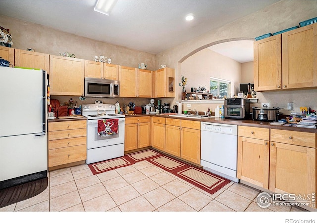 kitchen featuring white appliances, light brown cabinets, sink, and light tile patterned floors