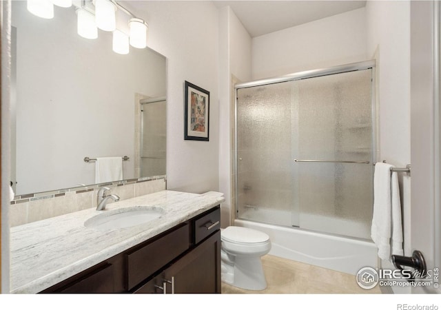 full bathroom with shower / bath combination with glass door, toilet, tile patterned flooring, and vanity