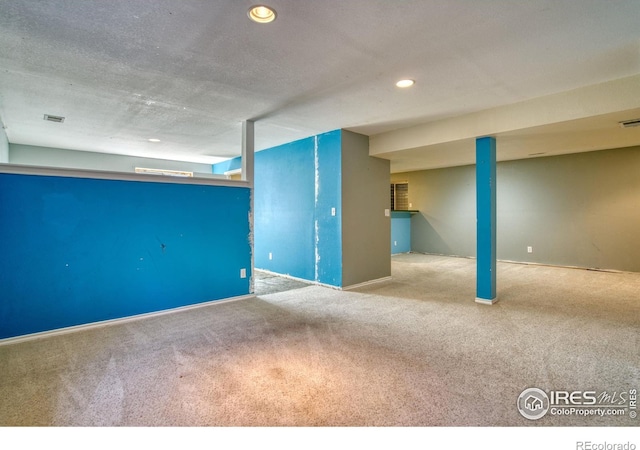 basement with light carpet and a textured ceiling