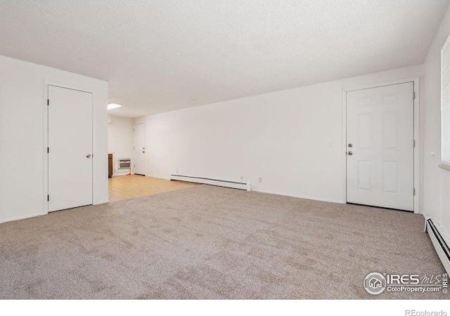 unfurnished room with a textured ceiling, a baseboard heating unit, and light colored carpet