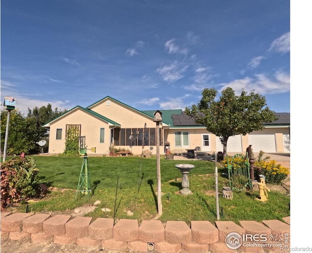 ranch-style house with a front lawn, a garage, roof mounted solar panels, and stucco siding