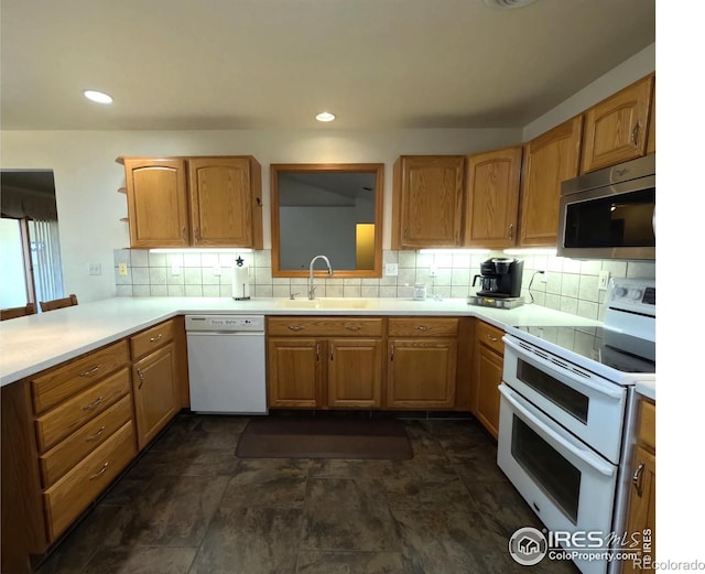 kitchen with white appliances, recessed lighting, a sink, light countertops, and backsplash