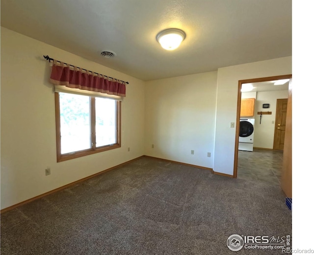 spare room with visible vents, washer / clothes dryer, baseboards, and carpet floors